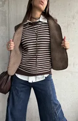Sweater de punto a rayas horizontales en color chocolate y blanco, con cuello redondo y mangas largas con detalle de botones en los puños.