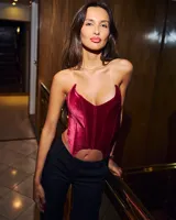 Corset negro con escote corazón pronunciado y corte irregular en el bajo.