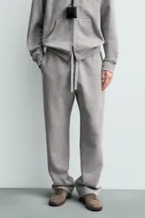 Pantalón jogger de corte regular fit y color negro, confeccionado en tejido compacto de algodón con interior de rizo. Cuenta con cintura elástica, bolsillos frontales y un bolsillo trasero de doble vivo.