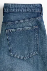 Bermuda de cinco bolsillos en denim de algodón rígido, con diseño de corte holgado, cierre y botón.