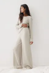 Pijama de dos piezas confeccionado en punto cepillado de viscosa. Incluye una remera de manga larga con cuello redondo y detalles de terminación ondulada en puños y bajo, y un pantalón de corte recto con cintura elástica y terminación ondulada en el ruedo.