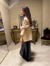 Jean de corte flared confeccionado en denim negro lavado, con aplicación lateral de encaje con flecos y lentejuelas.