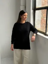 Sweater de punto color negro con diseño de rombos sutilmente integrados en el tejido, cuello redondo y mangas largas con puños ajustados.