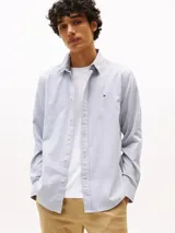 Camisa celeste de algodón regenerativo con textura dobby, cuello camisero clásico, cierre con botones y puños abotonados. Tiene corte regular, manga larga y logo de Tommy Hilfiger bordado en el pecho.