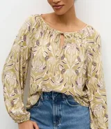Blusa de manga larga con estampado geométrico en tonos verdes y violetas, cuello redondo con detalle de amarre frontal y puños elásticos.