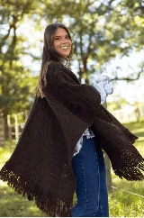Ruana de lana merino color marrón, con diseño de tejido de punto texturizado y terminaciones con flecos en los bordes.
