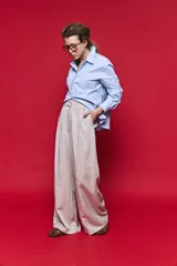 Pantalón tiro alto color beige, de calce amplio y diseño wide leg con pinzas delanteras, bolsillos laterales y presillas para cinturón.