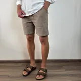 Bermuda de corte recto en color beige, confeccionada en tejido simil lino, con cintura elástica y cordón de ajuste.