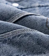 Campera de jean de corte regular, con cuello de solapa forrado en chenille, cierre frontal con botones metálicos y bolsillos frontales en el pecho.