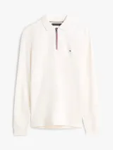 Chomba de manga larga Tommy Hilfiger color blanco, de corte regular y tejido de algodón suave. Presenta cuello clásico, cierre frontal parcial con cremallera y ribetes tricolores, además del logo bordado en el pecho.