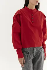 Camisa blanca de mangas dolman, cuello mao y pliegues en los hombros.