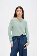Sweater de tejido de punto fino en color blanco, con cuello redondo a la base y mangas largas de corte holgado.