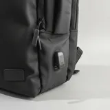 Mochila de viaje color negro con diseño funcional, compartimento para laptop y puerto USB integrado. Fabricada en material resistente al agua, cuenta con múltiples bolsillos internos y externos, y diseño antirrobo.