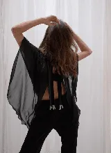 Capa corta color fucsia de gasa, estilo torerita, con mangas amplias y abertura frontal.