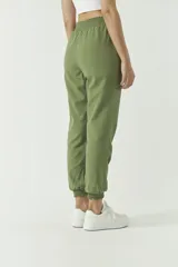Pantalón de corte holgado confeccionado en mezcla de algodón y lino, color tostado. Presenta cintura elástica con cordón ajustable y puños elásticos en los tobillos.