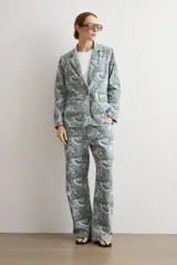 Blazer de jean con estampado paisley en tonos azules, grises y beige, de corte recto con solapas clásicas y bolsillos frontales con solapa.