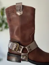 Bota de cuero marrón con estribo desmontable plateado.