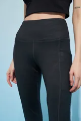 Calza deportiva larga color verde azulado con pretina alta y bolsillos laterales.