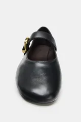Zapatos tipo bailarina en piel color negro, con tira delantera y hebilla metálica dorada ajustable, terminación en punta redonda y suela plana.