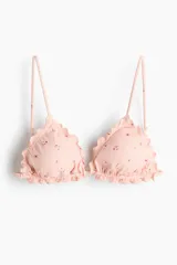 Top de bikini de triángulo con ribetes sobrehilados, breteles ajustables y copas con relleno extraíble, de color rosado con estampado floreado.