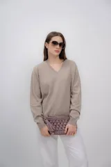 Sweater color beige de cashmere con escote en V y mangas largas.