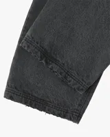 Jean de corte recto y tiro medio, color negro lavado. Presenta bolsillos traseros con detalle de parche bordado con el logo de la marca y etiqueta de cuero en la cintura.