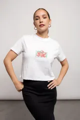 Remera blanca de algodón con estampado de fresas y texto en color coral y verde.
