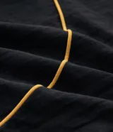 Pantalón deportivo de microfibra color negro, con corte holgado y diseño de piping contrastante en color amarillo. Cuenta con cintura elástica con cordón de ajuste, bolsillos laterales y logo bordado.