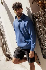 Canguro azul con capucha y bolsillo tipo canguro, estampado con texto en el frente.