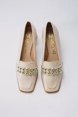 Zapato clásico color beige con textura croco, taco cuadrado y punta cuadrada.