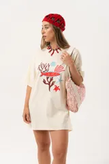 Remerón color crema de algodón con estampado de motivos marinos en tonos rojo y azul. De calce oversize y largo extendido.