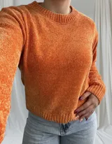 Sweater de punto color naranja, con cuello redondo y mangas largas.