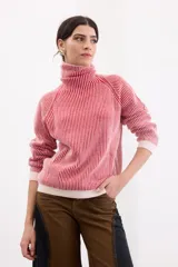 Sweater de punto con cuello tortuga y diseño a rayas verticales en color rojo y blanco. Presenta mangas largas con puños y ruedo en tejido liso de color crema, con un sutil acabado brillante.