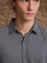 Camisa de manga larga color azul marino, con cuello clásico y cierre frontal de botones.