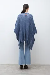 Ruana de punto color azul con estampado de espiga en dos tonos de azul, diseño holgado, con bolsillos y flecos en el borde inferior.