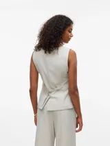 Chaleco sastrero color crema con cierre de botones al frente y bolsillos delanteros.