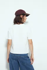 Remera blanca de manga corta con cuello redondo, aberturas laterales y bordado frontal con la frase "LIMITED EDITION" en negro.