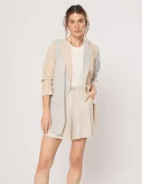Blazer oversized de corte recto en lino, color beige y gris. Largo a la cadera, con hombreras finitas forradas, costuras internas con sesgo combinado y bolsillos delanteros.