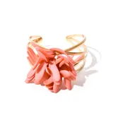 Brazalete dorado con diseño floral anaranjado.