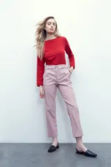 Pantalón rosa pastel con cintura elastizada, bolsillos laterales y cinto con hebilla metálica.
