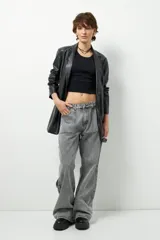 Jean de corte carpenter, estilo wide leg y tiro bajo, en color gris lavado. Presenta diseño de bolsillos frontales tipo parche y costuras reforzadas.