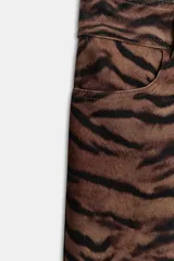 Pantalón de tiro medio con corte barrel, caracterizado por su silueta holgada en cadera y muslos que se estrecha hacia el tobillo. Presenta estampado animal print, bolsillos delanteros y cierre frontal con cremallera, botón y gancho.