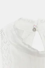 Camisa rosa de cuello alto, mangas cortas abullonadas y detalles de encaje y entredós en el frente y las mangas.