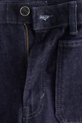 Pantalón de jean color azul marino, de tiro alto y corte wide leg, con amplios bolsillos frontales de parche y presillas para cinturón.