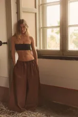 Pantalón negro de tiro medio, estilo culotte, con cintura elástica fruncida y piernas muy anchas. Posee bolsillos laterales ocultos.