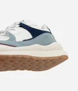 Championes estilo jogging con diseño de recortes contrastantes en tonos blanco, azul y gris. Presenta una parte superior de mesh respirable con sobreposiciones de poliuretano, forro suave y suela robusta de color crema con base marrón.
