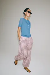 Pantalón bombacho de tiro medio, confeccionado en mezcla de algodón con estampado de cuadros en tonos rosados y oscuros. Presenta cintura elástica y bajo abullonado con puño elástico.