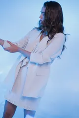 Minifalda color crudo de lino, corte recto, con flecos de algodón en el ruedo, forro de la misma tela y cierre invisible trasero.