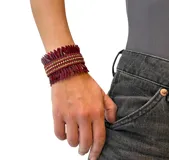 Pulsera tipo brazalete hecho en lentejuelas delgadas color borgoña y strass dorados.