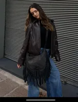 Cartera bandolera de cuero color negro con flecos largos en la parte inferior.